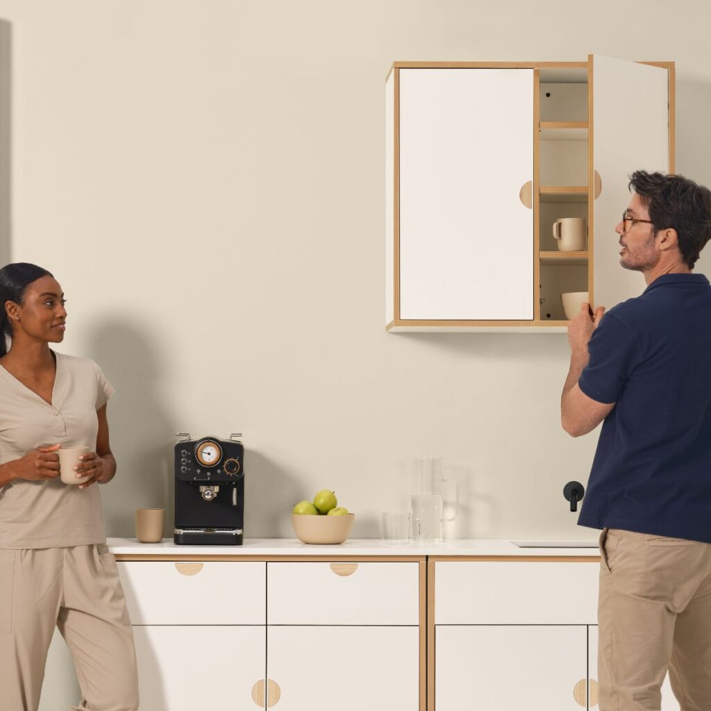 Moderne keuken met mensen, koffiezetapparaat en meubels.