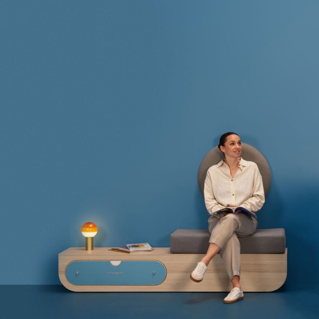 Vrouw zit op moderne meubel met lamp en boek.